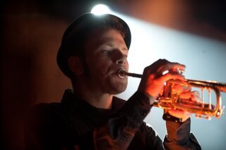 Uno dei trombettisti sul palco con Dente